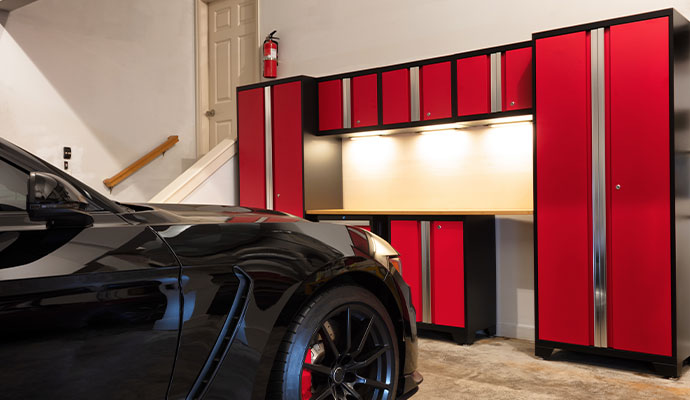 Modern garage with red storage cabinets Organized garage with red cabinets and a black sports car