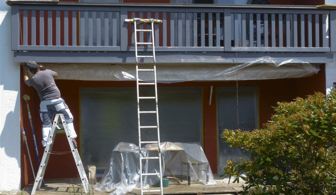 an Expert painting exterior of a house