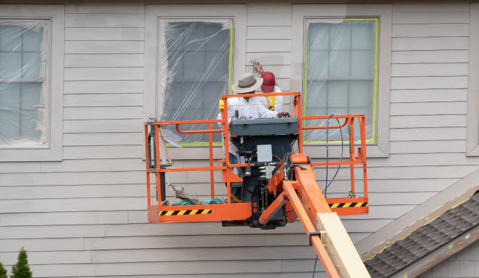 Experts painting vinyl siding surface