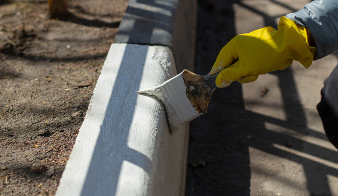 painter painting the side of a walkway