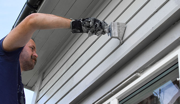 a man painting exterior of a house