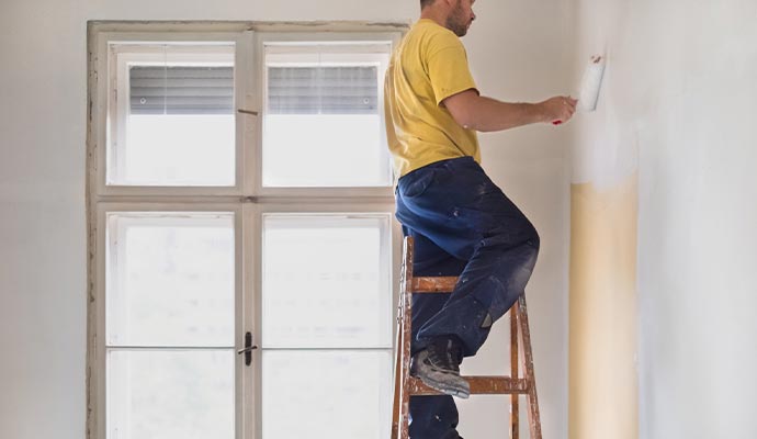 Person painting interior of a room