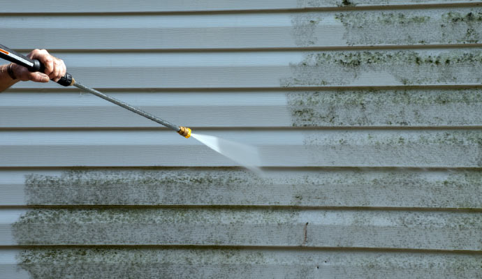 Pressure washing a house exterior